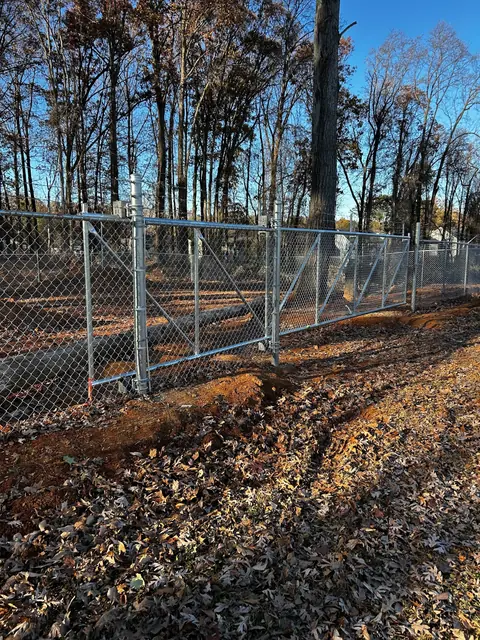 Galvanized chain link double swing gate at a commercial lot.