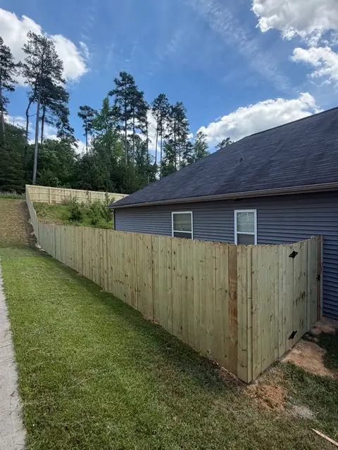 Dog-ear wood privacy fence stepping down a side yard.
