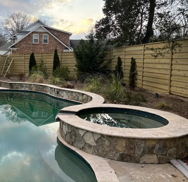 Horizontal wood privacy fence around a backyard pool and spa.