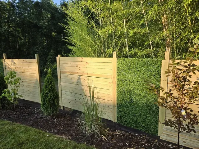 Horizontal wood privacy screen panels alternating with hedge panels.