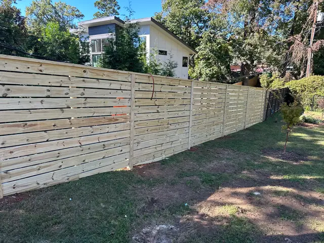 Horizontal wood semi-privacy fence along a backyard.