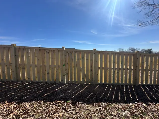 Shadowbox wood fence with post caps.