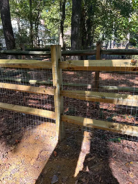 Close view of split rail fence rails, post and welded wire mesh.
