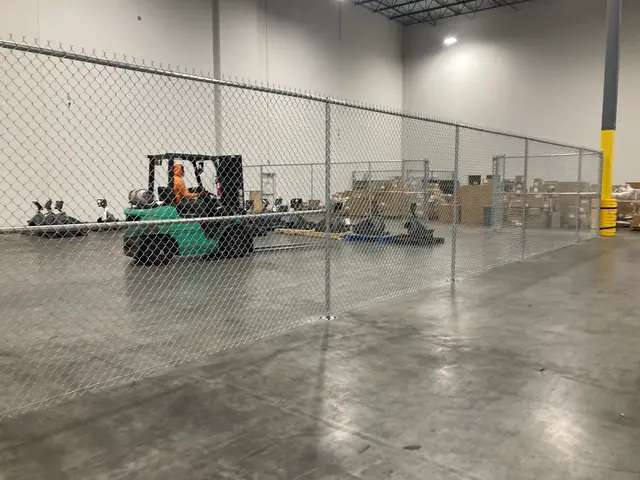 Galvanized chain link partition fence inside a warehouse.