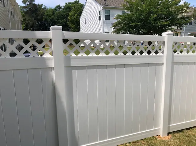 White vinyl privacy fence with a lattice top.