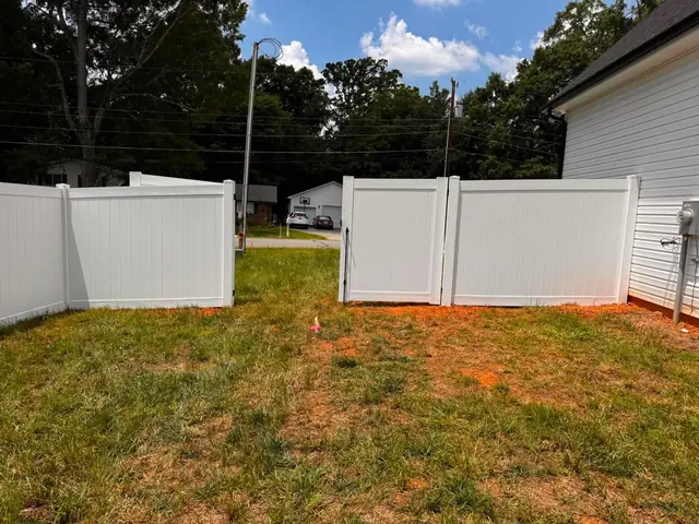 White vinyl privacy fence with a double gate.