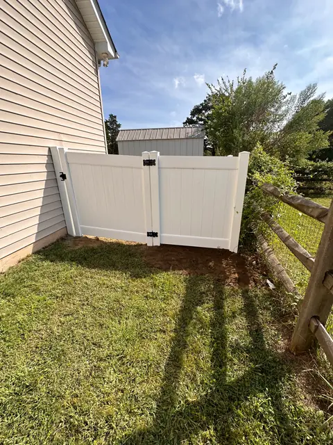 White vinyl privacy gate at the side of a house.