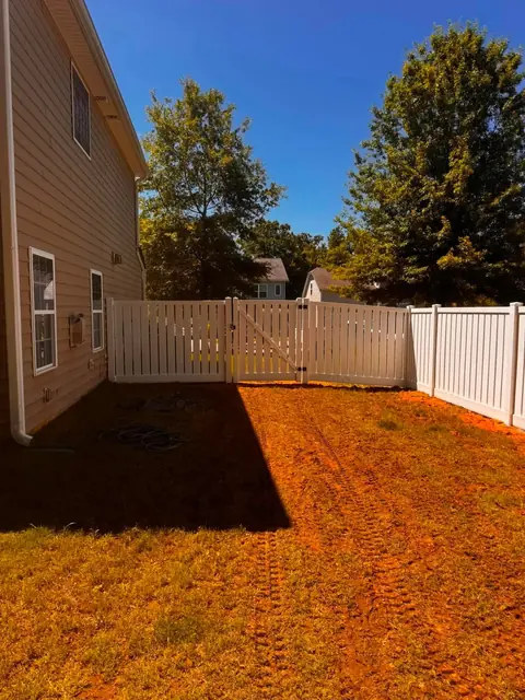 White vinyl semi-privacy fence with a double gate.