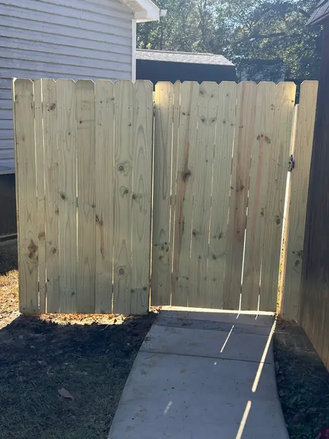 Wood privacy double gate between two houses.