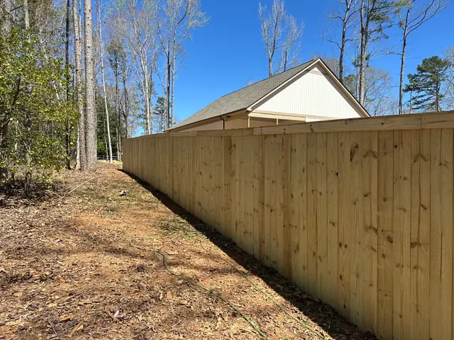 Long run of wood privacy fence with cap and trim.